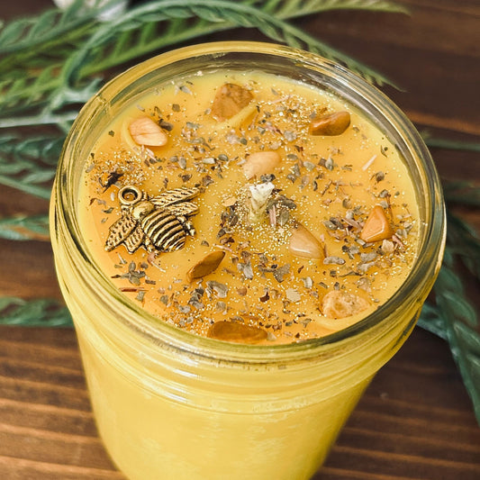 A dark Halloween candle that is decorated with a scary skeleton, a spooky rest in peace sign, white crystals, and gothic black glitter.