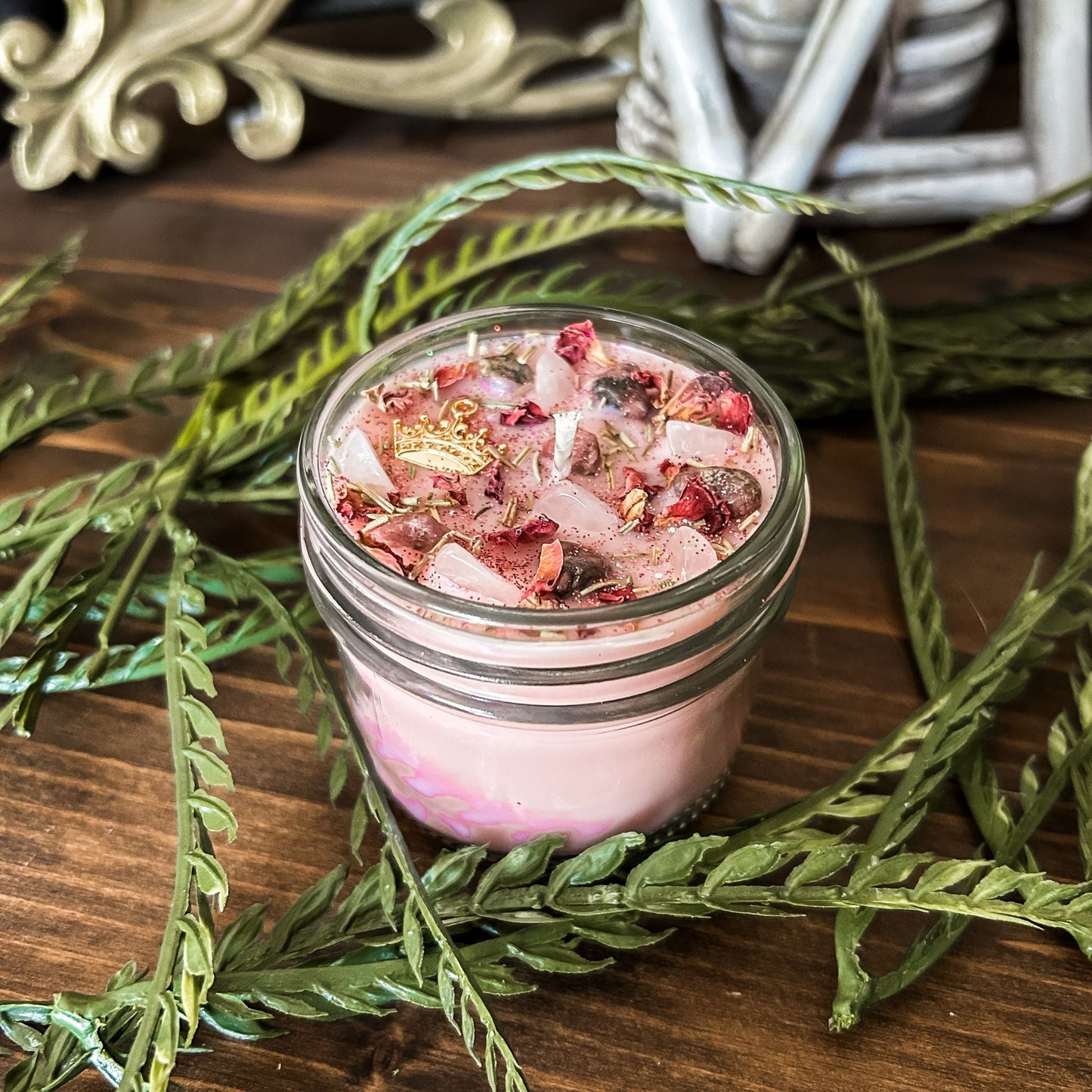 Pink intention crystal candle that is decorated with a princess crown charm, pink magic glitter. The candle also has crystals and herbs for manifesting self-love and confidence.
