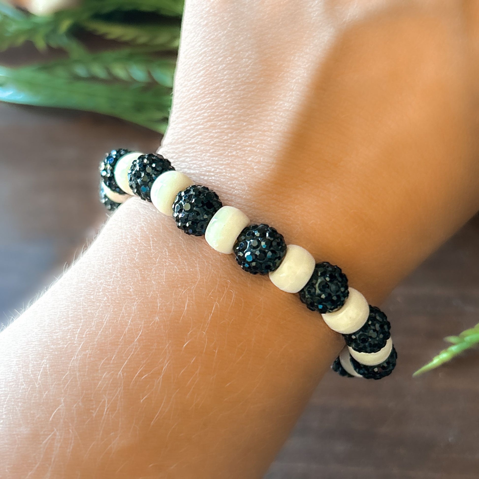 Halloween Bracelet with sparkly black and white beads with letters that say Spooky. The bracelet also has a ghost spider.