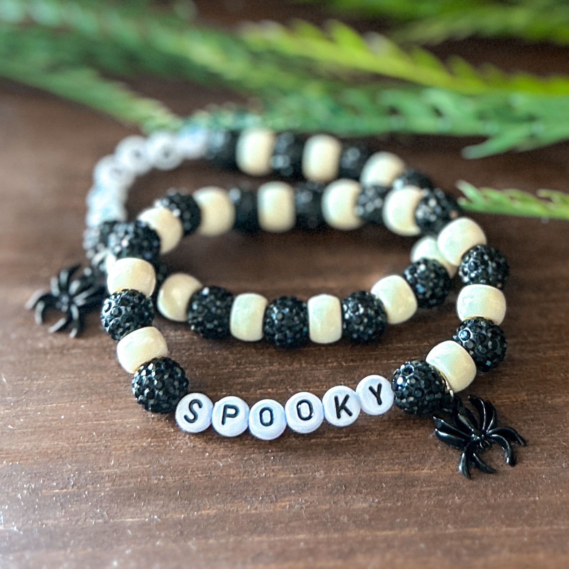 Halloween Bracelet with sparkly black and white beads with letters that say Spooky. The bracelet also has a ghost spider.