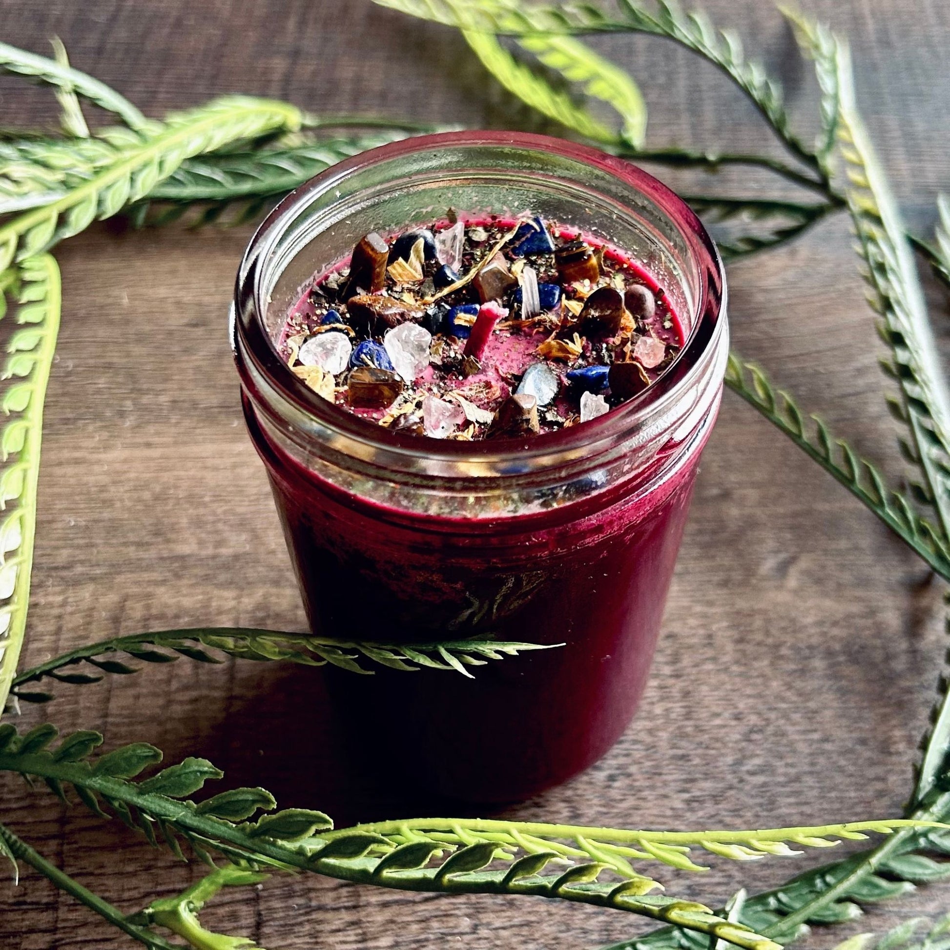 Pagan Intention candle that is decorated with witchy crystals, flowers, and magic glitter to represent Mabon.