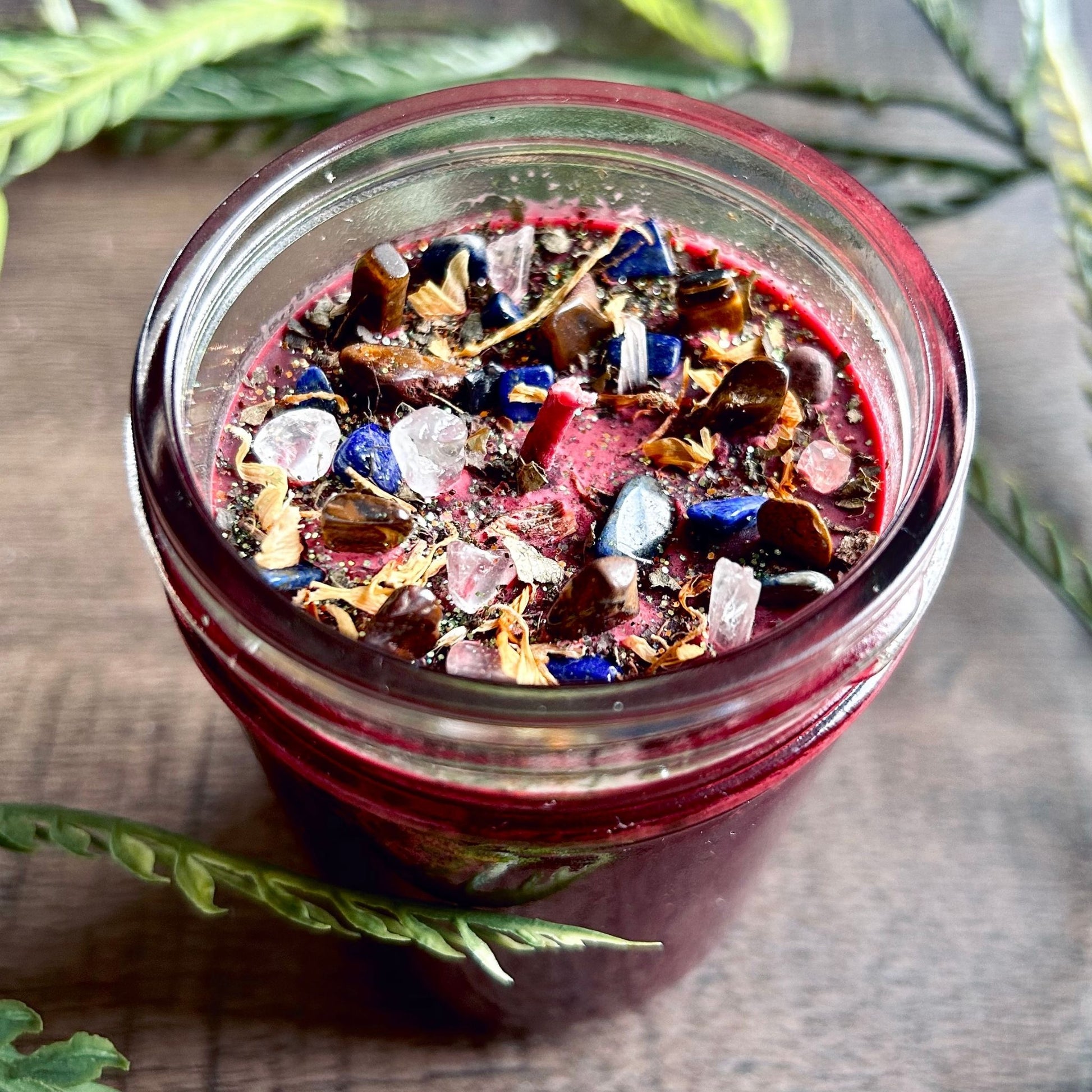 Pagan Intention candle that is decorated with witchy crystals, flowers, and magic glitter to represent Mabon.