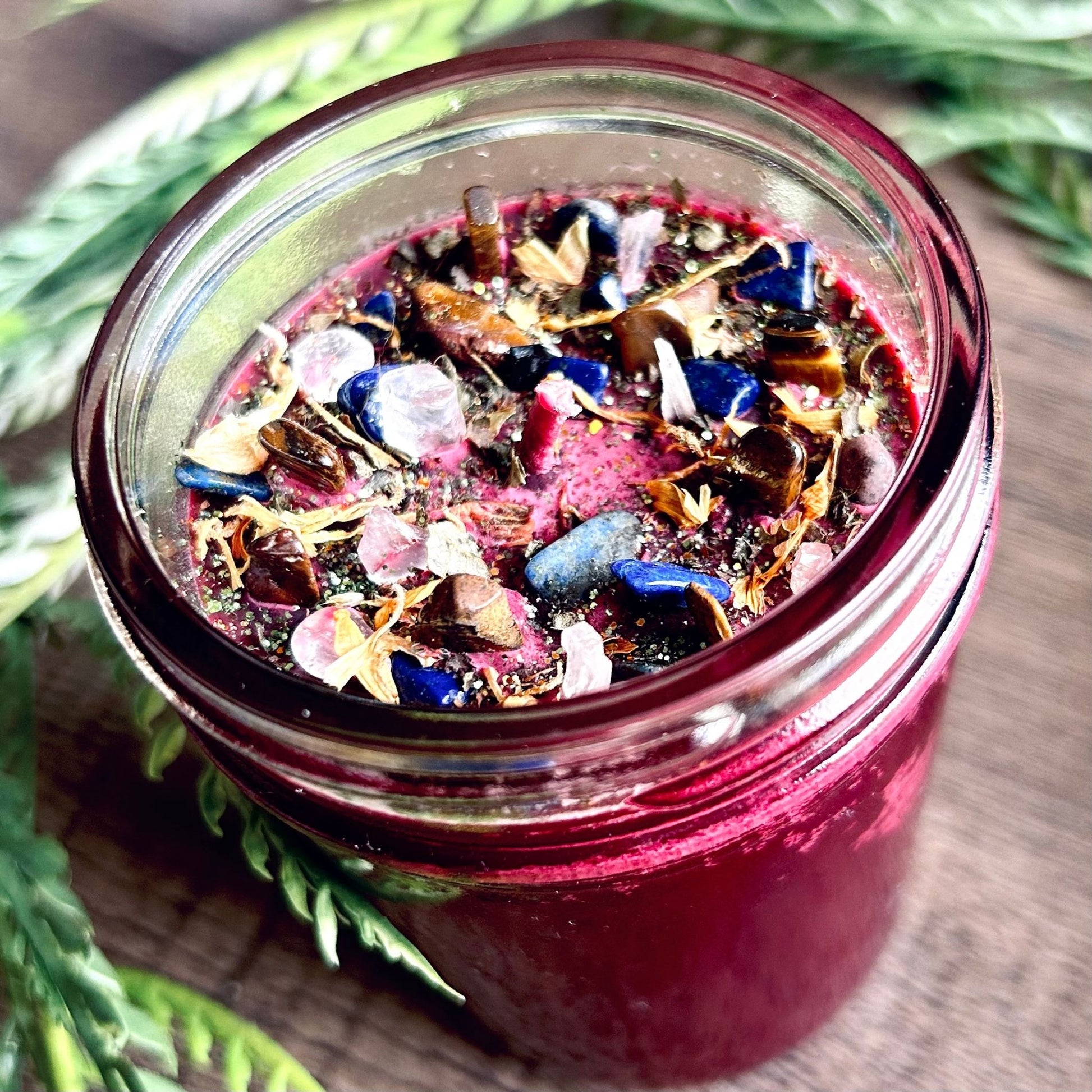 Pagan Intention candle that is decorated with witchy crystals, flowers, and magic glitter to represent Mabon.