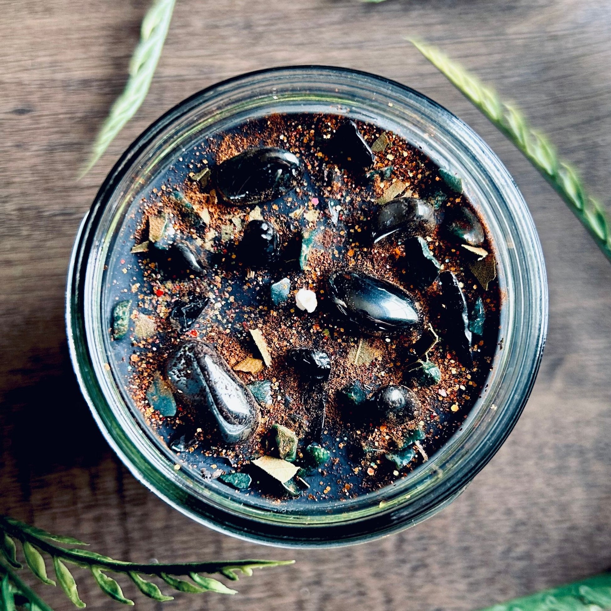 Pagan Intention candle that is decorated with witchy crystals, spooky flowers, and Halloween glitter to represent the witches' new year and the Samhain Sabbat.