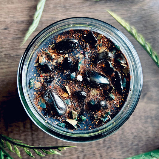 Pagan Intention candle that is decorated with witchy crystals, spooky flowers, and Halloween glitter to represent the witches' new year and the Samhain Sabbat.