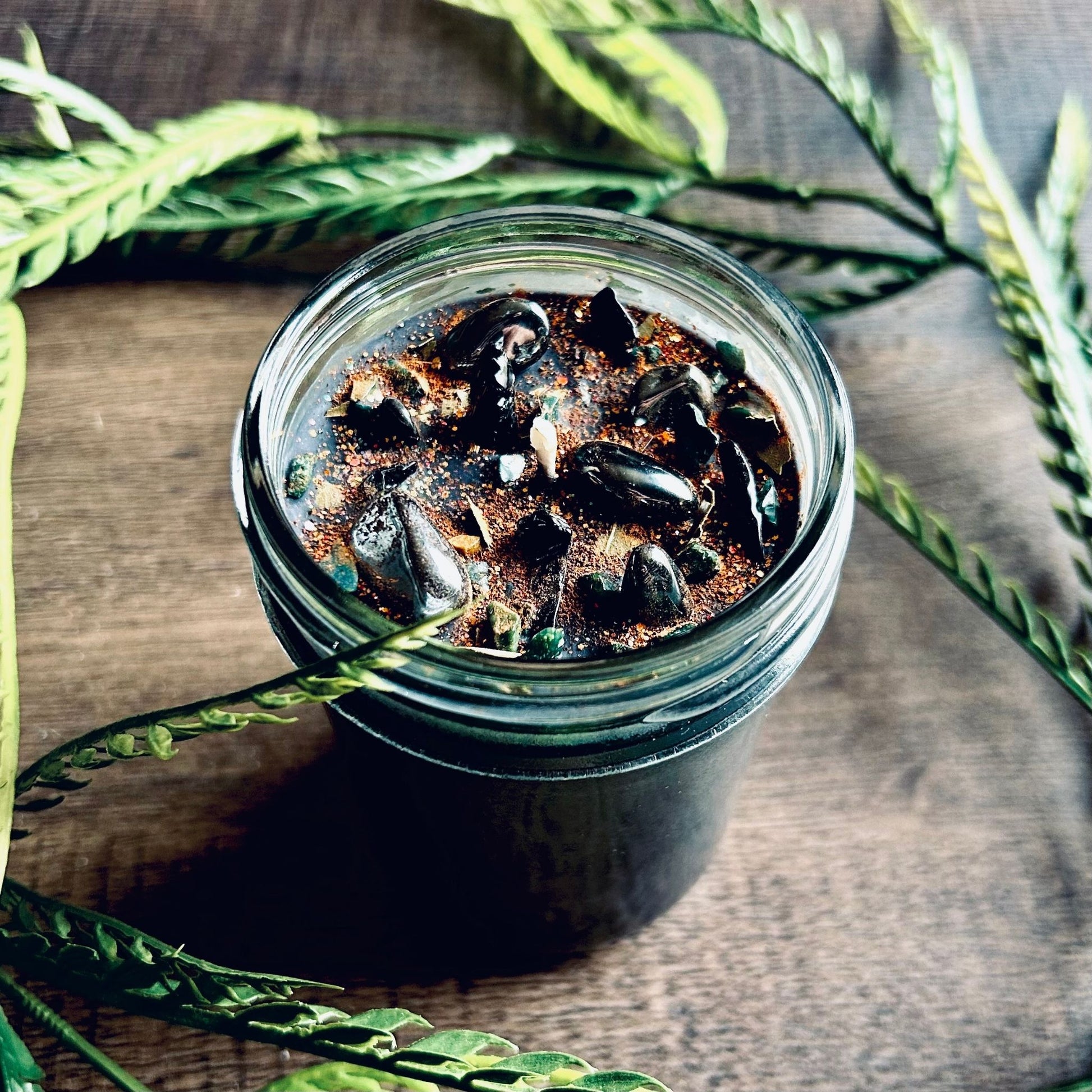 Pagan Intention candle that is decorated with witchy crystals, spooky flowers, and Halloween glitter to represent the witches' new year and the Samhain Sabbat.