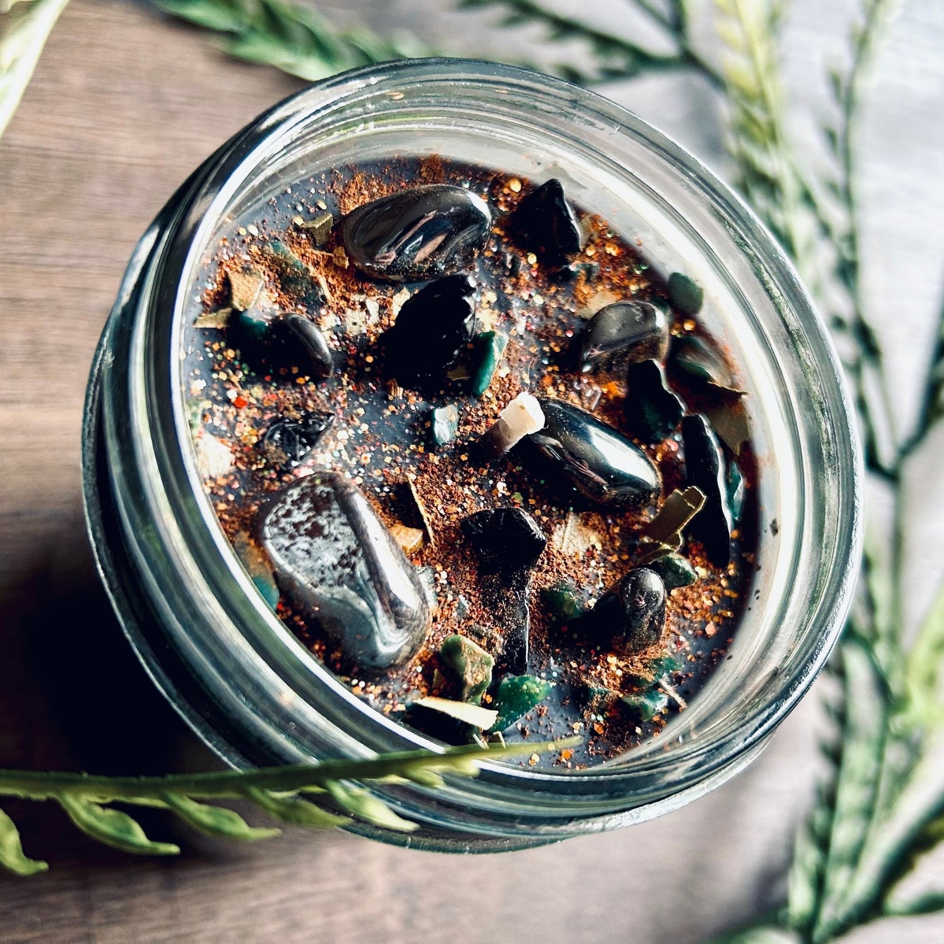 Pagan Intention candle that is decorated with witchy crystals, spooky flowers, and Halloween glitter to represent the witches' new year and the Samhain Sabbat.