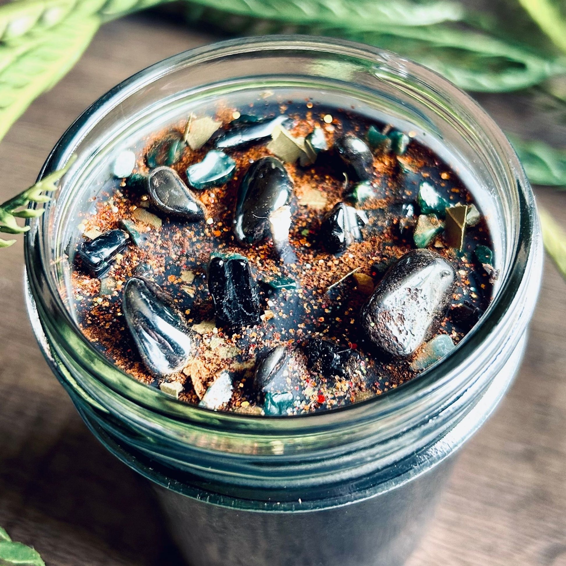 Pagan Intention candle that is decorated with witchy crystals, spooky flowers, and Halloween glitter to represent the witches' new year and the Samhain Sabbat.