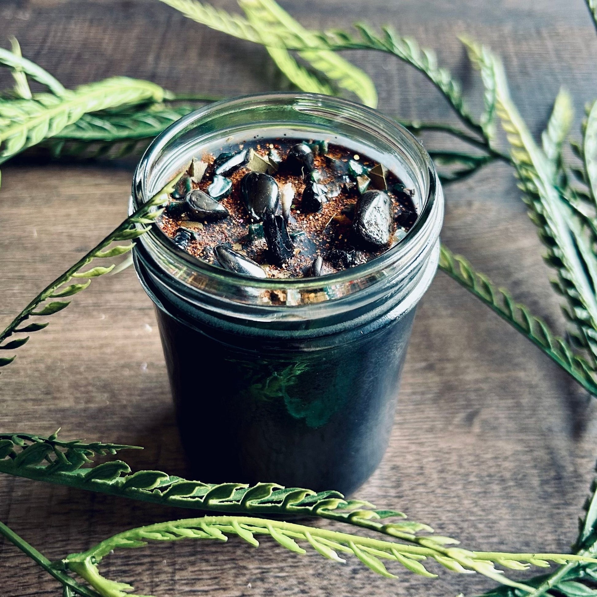 Pagan Intention candle that is decorated with witchy crystals, spooky flowers, and Halloween glitter to represent the witches' new year and the Samhain Sabbat.