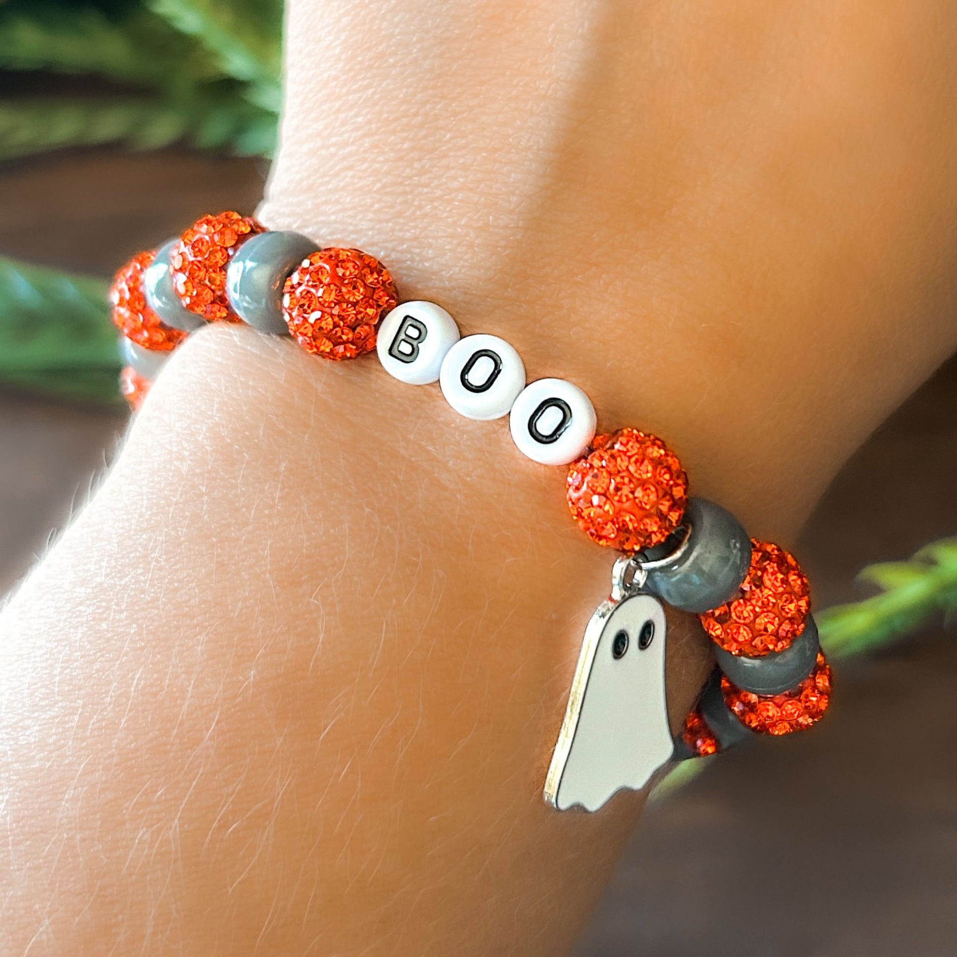 Halloween Bracelet with sparkly orange and gray beads with letters that say Boo. The bracelet also has a ghost charm.