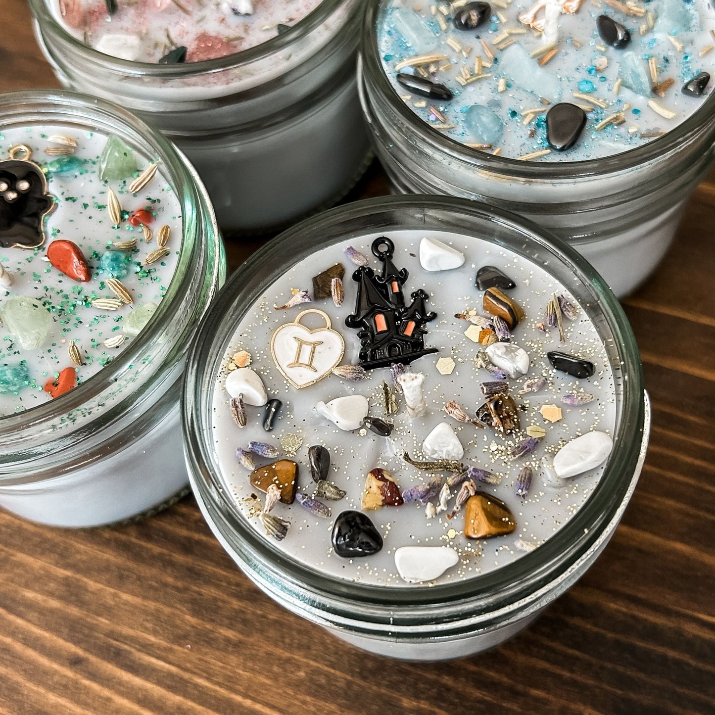 Spooky Gemini Zodiac Candles with crystals, herbs, glitter, and a Halloween design.