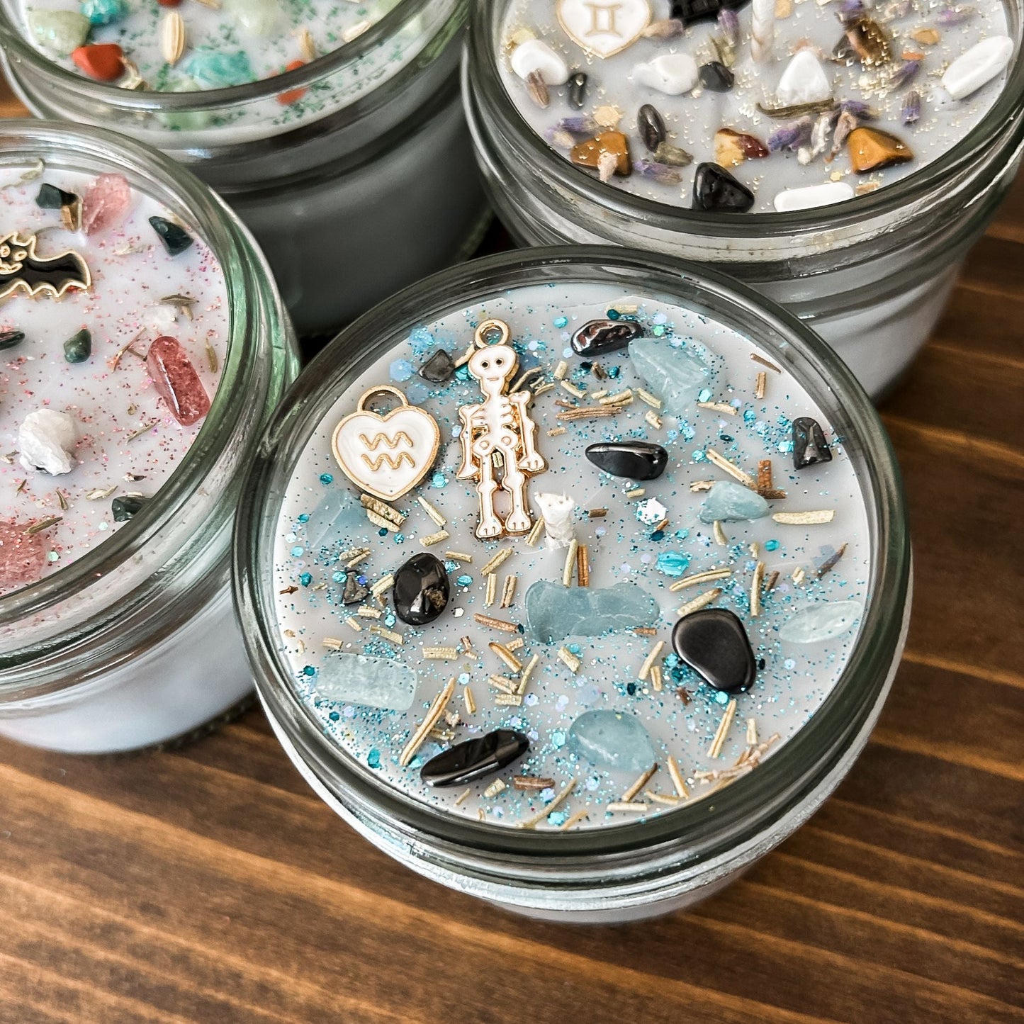 Spooky Aquarius Zodiac Candles with crystals, herbs, glitter, and a Halloween design.