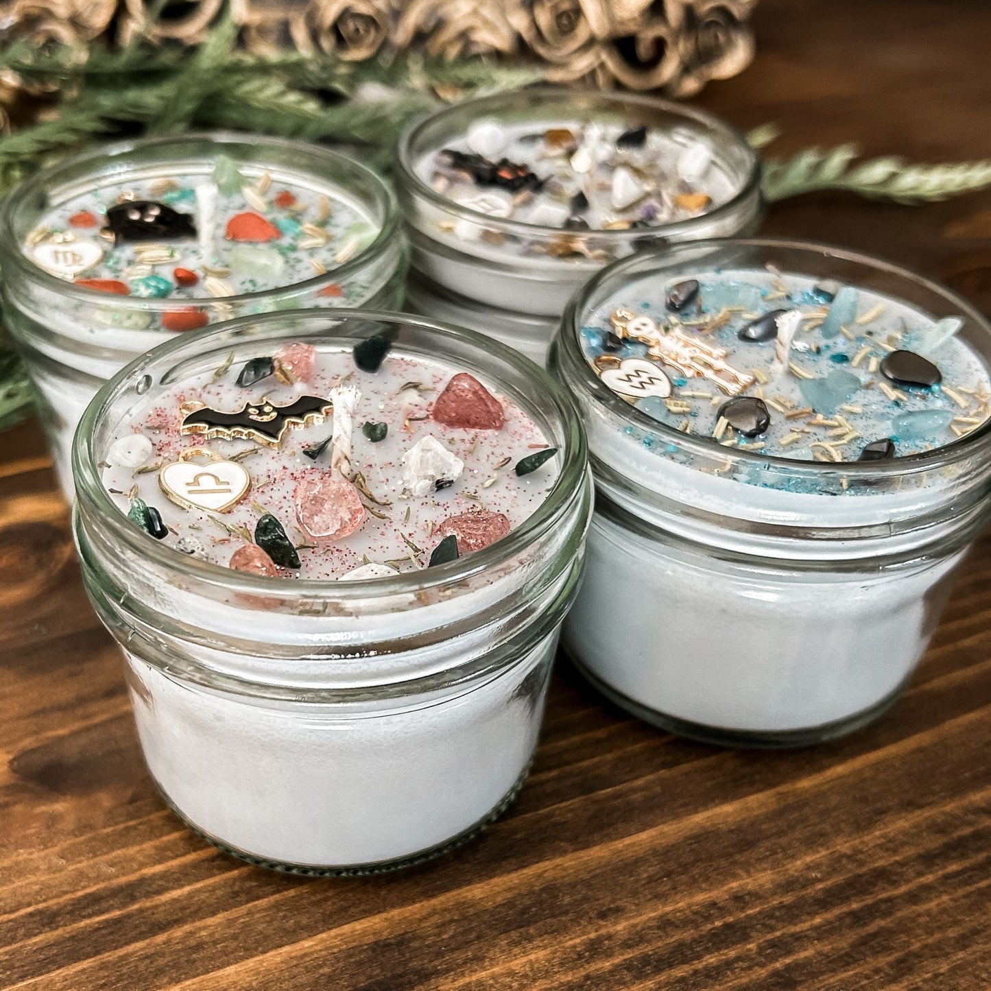 Spooky Zodiac Candles with crystals, herbs, glitter, and a Halloween design.