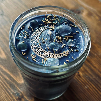 Celestial moon magic ritual candle with crystals, herbs, and a crescent moon.