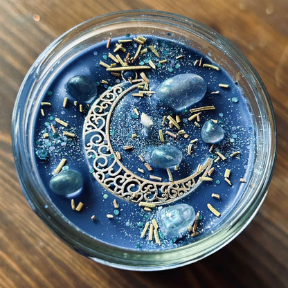 Celestial moon magic ritual candle with crystals, herbs, and a crescent moon.