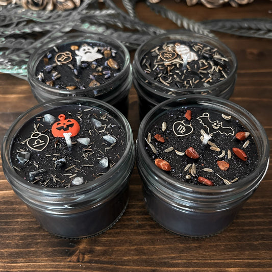Spooky Black Zodiac Candles with crystals, herbs, glitter, and a Halloween design.