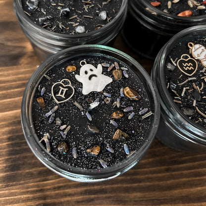Spooky Gemini Zodiac Candles with crystals, herbs, glitter, and a Halloween design.