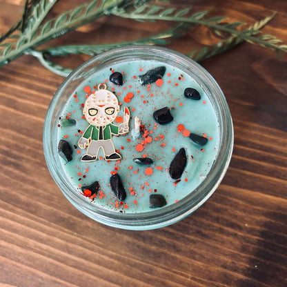 A blue Halloween candle with a Jason Voorhees horror movie charm, spooky crystals, and gothic glitter.