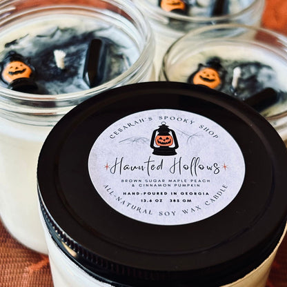 A white Halloween candle with black swirls. The candle is decorated with a spooky jack o lantern and a black obsidian crystal.