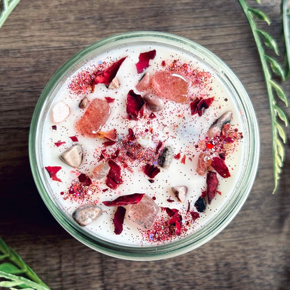 White love spell intention candle with rose quartz crystals and rose petals for love rituals and manifestation.