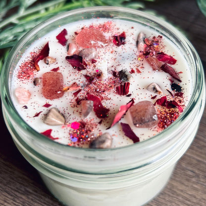 White love spell intention candle with rose quartz crystals and rose petals for love rituals and manifestation.