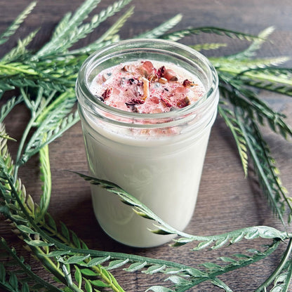 White love spell intention candle with rose quartz crystals and rose petals for love rituals and manifestation.