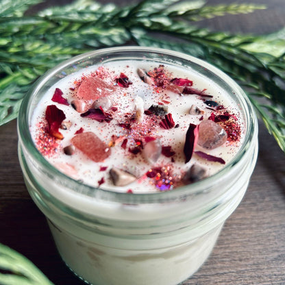 White love spell intention candle with rose quartz crystals and rose petals for love rituals and manifestation.