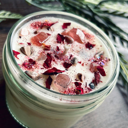 White love spell intention candle with rose quartz crystals and rose petals for love rituals and manifestation.