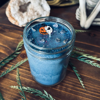 A blue Halloween candle that is decorated with a nightmare before Christmas Jack Skellington, spooky crystals, and creepy glitter.