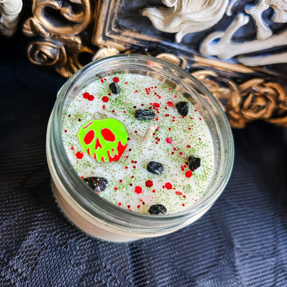 A Halloween candle decorated with a spooky melting apple charm, witchy crystals, and gothic glitter.